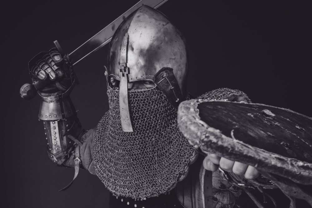 The Bomb of Galahad Satire: Image depicts a knight in full armor raising a sword.